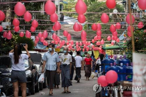 양곤 시내 상점가에 쿠데타 항의의 표시로 빨간 풍선들이 매달려 있다.   [로이터=연합뉴스]